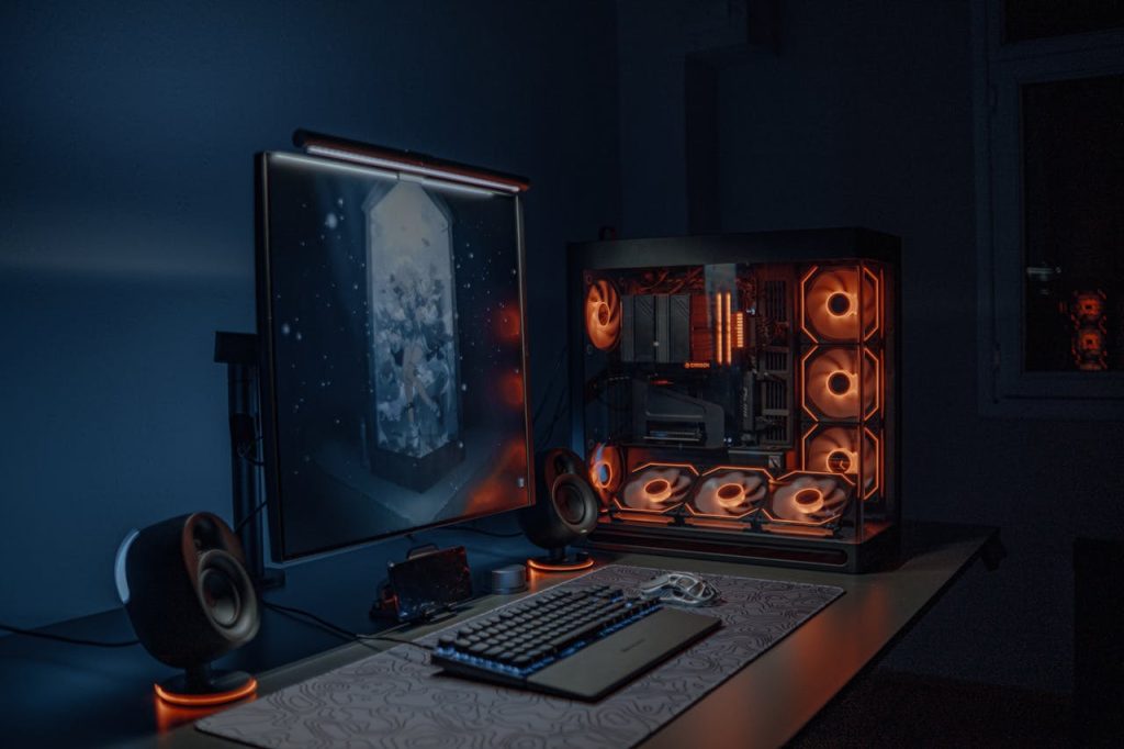 pexels-photo-30469968 A sleek gaming PC setup with LED lights, monitor, and keyboard in a dimly lit room.