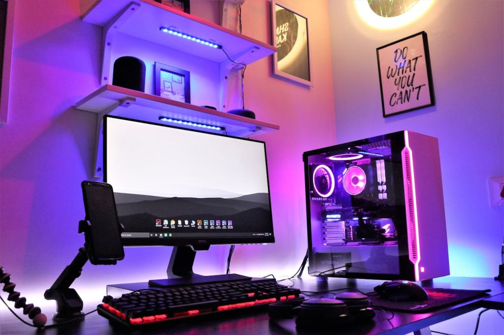 pexels-photo-7199194 A sleek gaming setup featuring RGB lighting with a desktop, monitor, and smartphone in a vibrant room.
